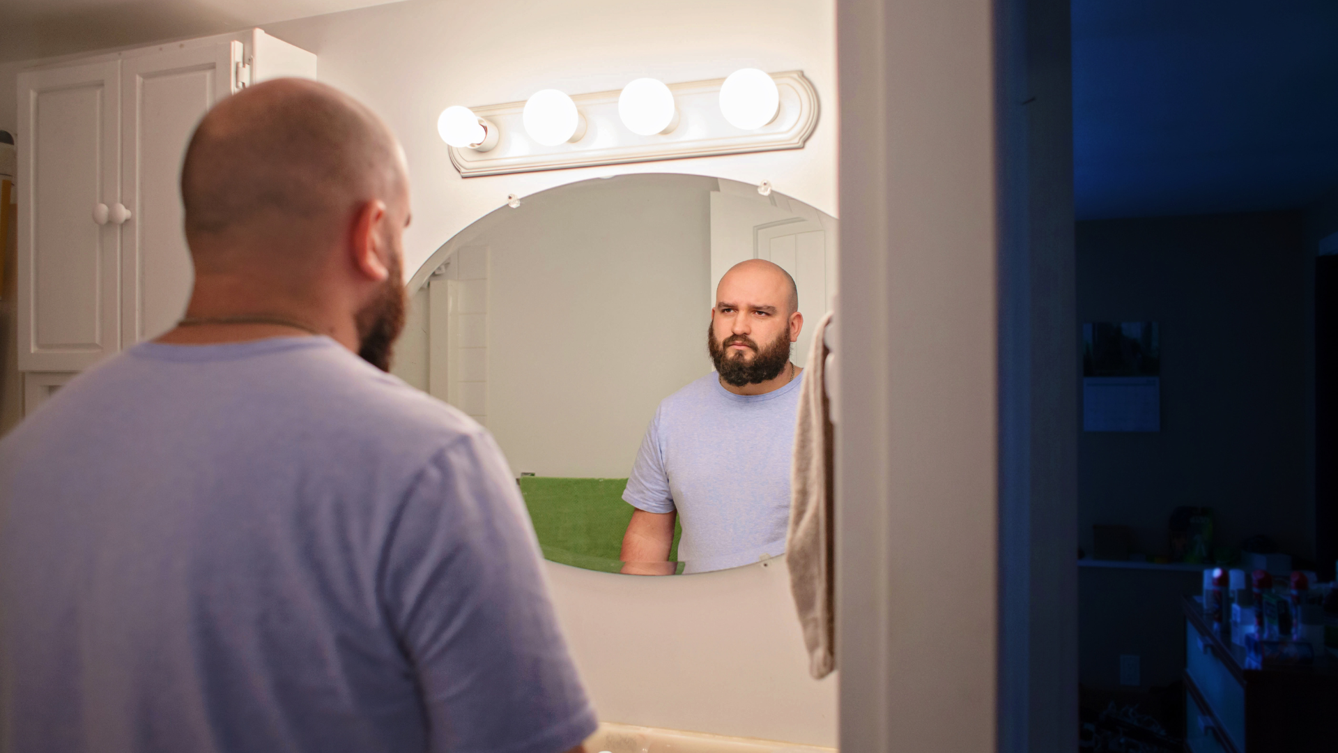 A man looking in the mirror reflects on his own self image.